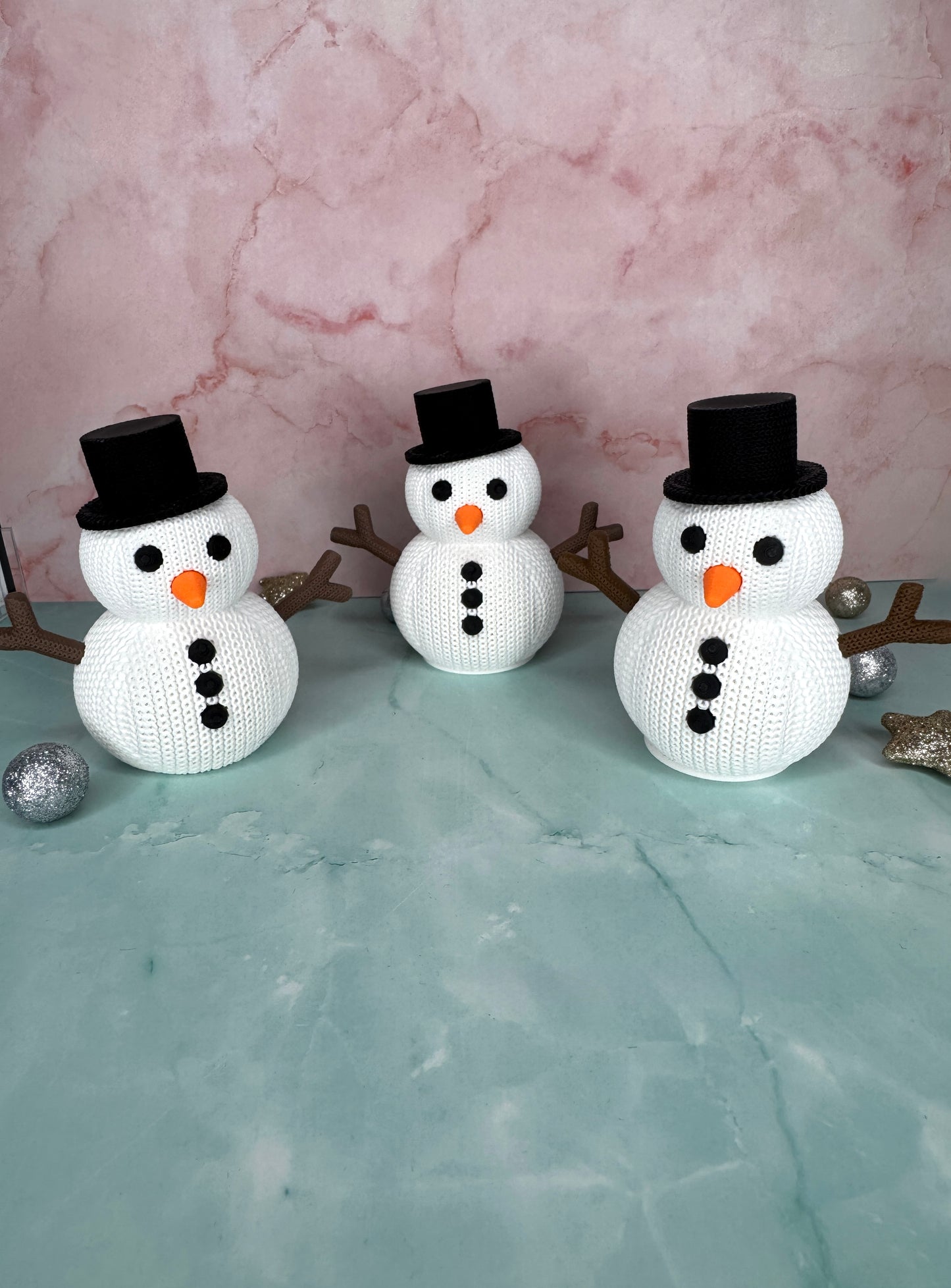 Drei kleine 3D-gedruckte Schneemänner im gestrickten Look von vorne, Platz für LED-Teelicht im Innenraum