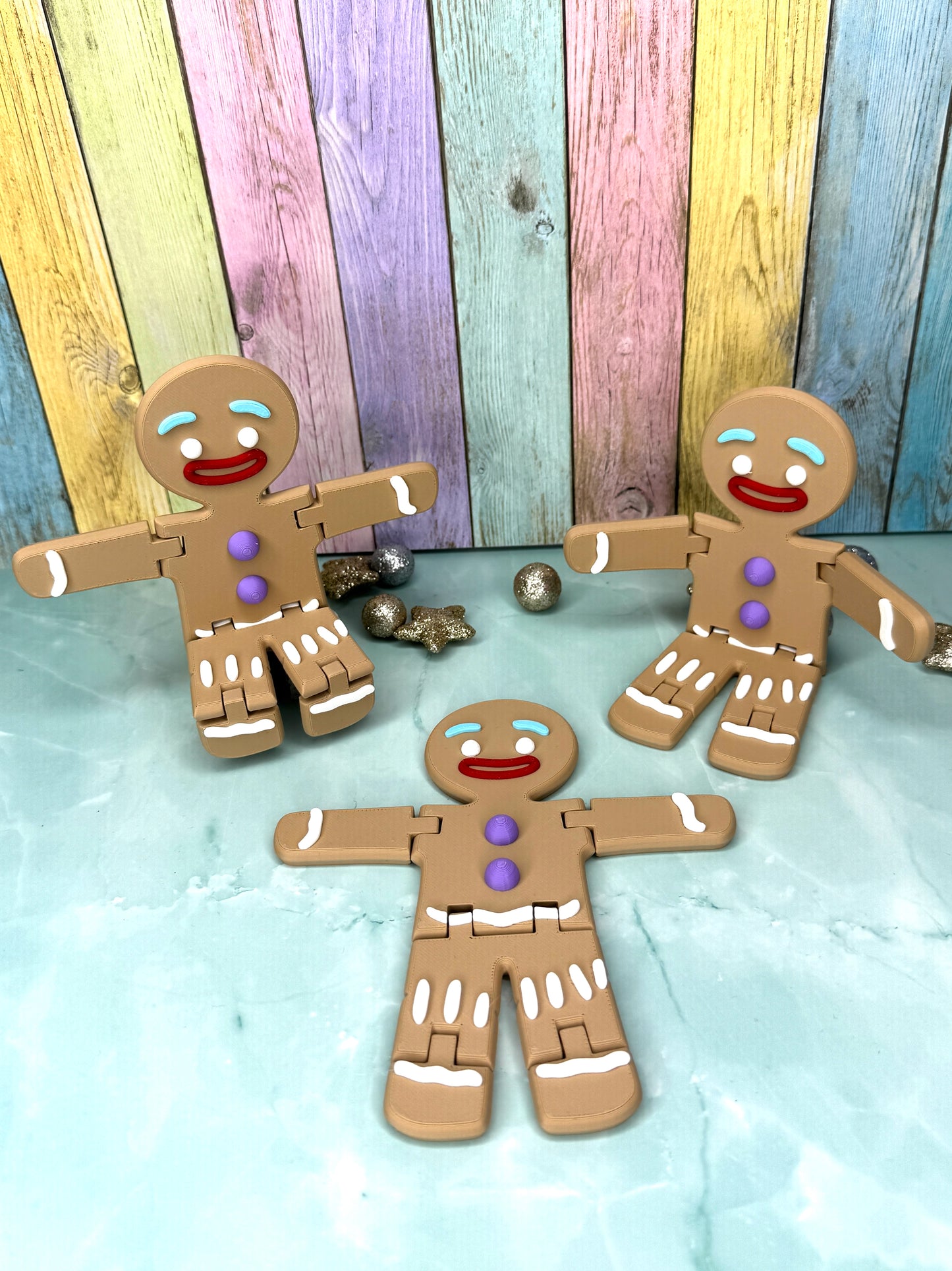 drei 3D-gedruckter Lebkuchenmaenner mit frei beweglichen Armen und Beinen sitzend und liegend