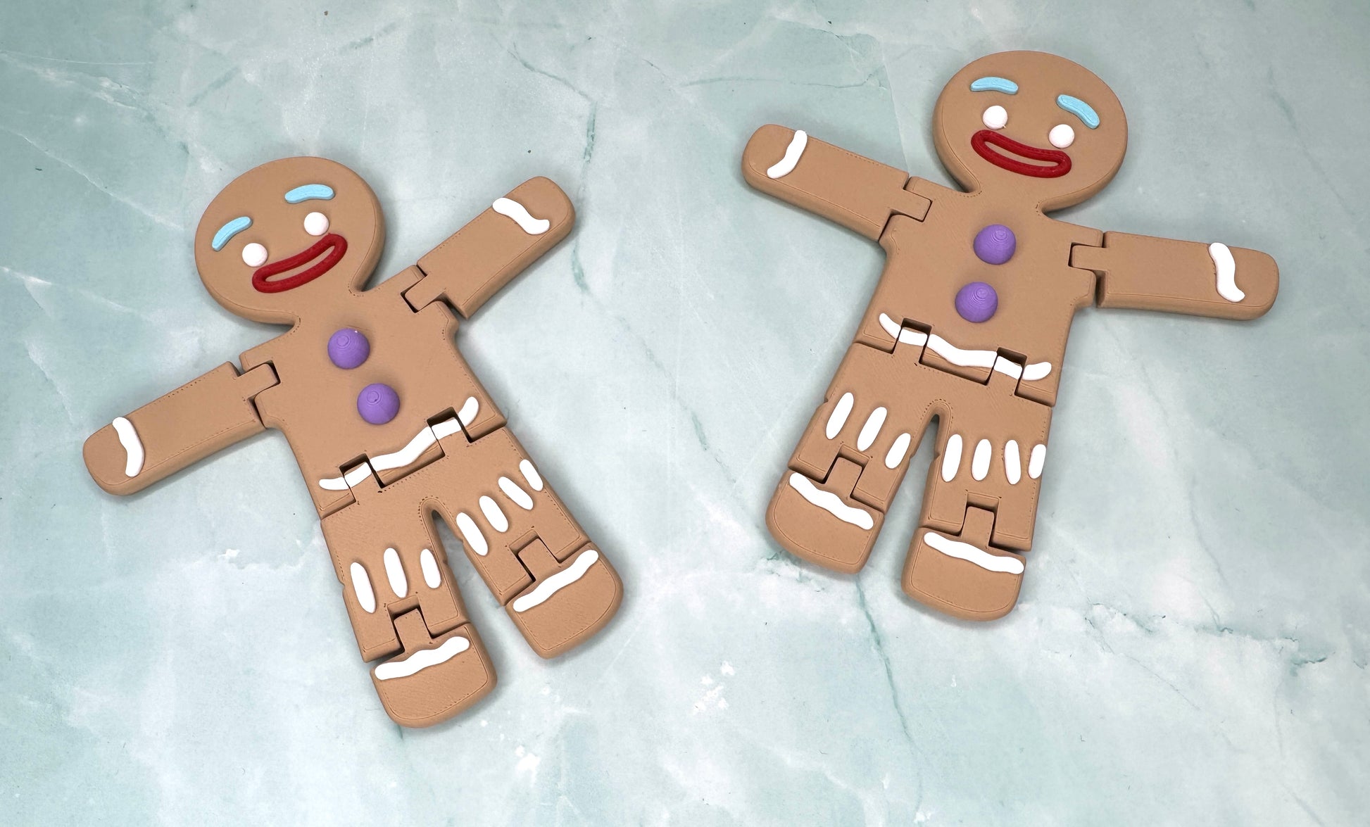 zwei 3D-gedruckte Lebkuchenmaenner mit frei beweglichen Armen und Beinen liegend