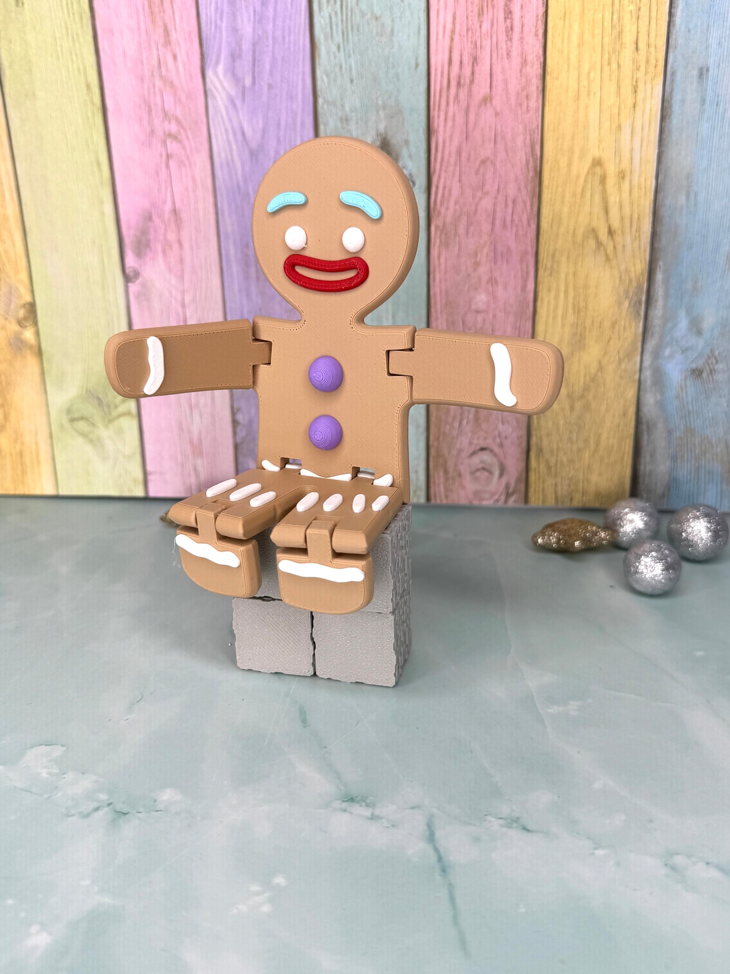 3D-gedruckter Lebkuchenmann mit frei beweglichen Armen und Beinen sitzend seitlich