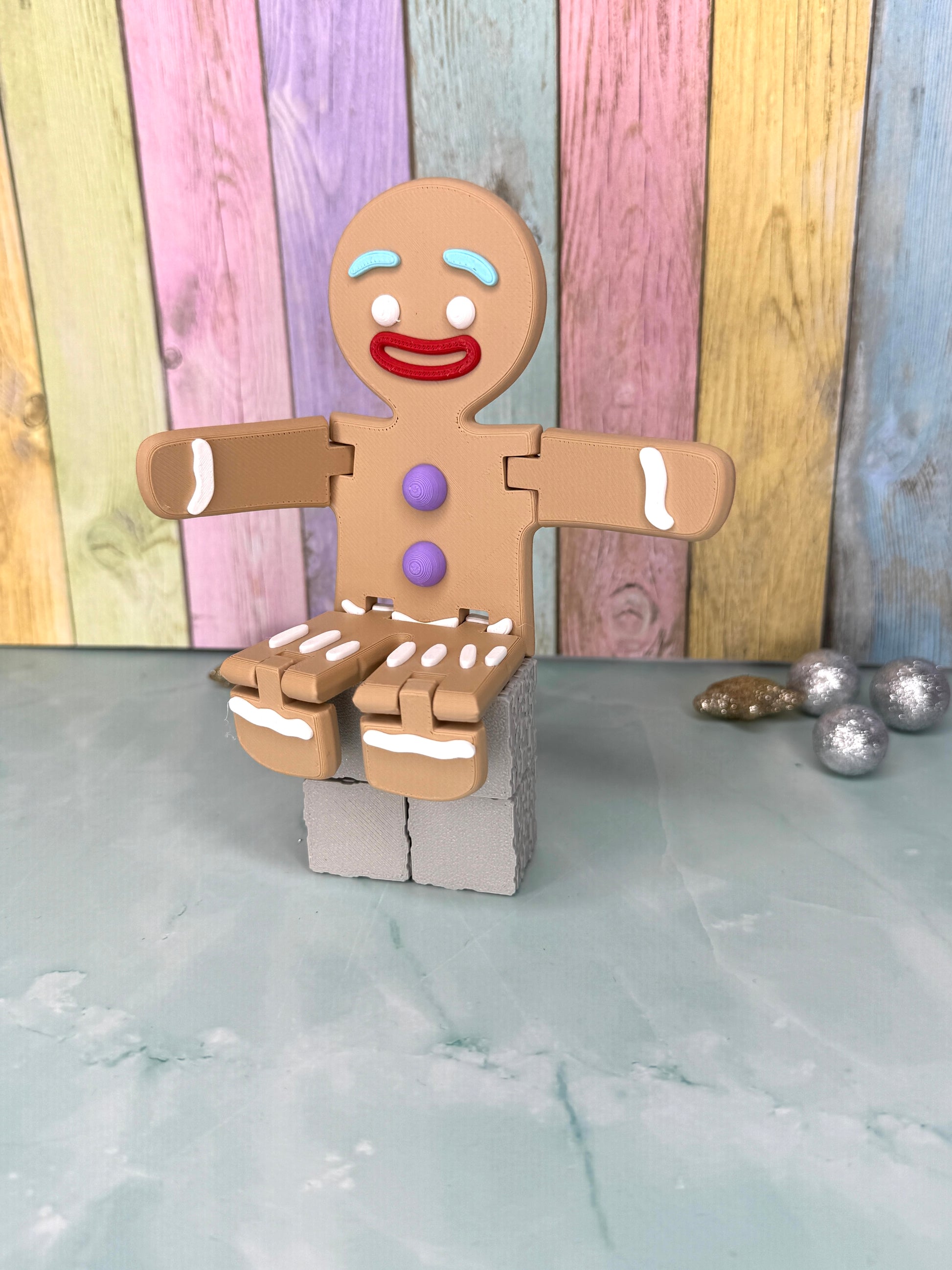 3D-gedruckter Lebkuchenmann mit frei beweglichen Armen und Beinen sitzend seitlich